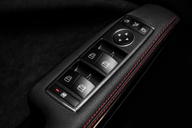 Close up of a door control panel in a new modern car. arm rest ...